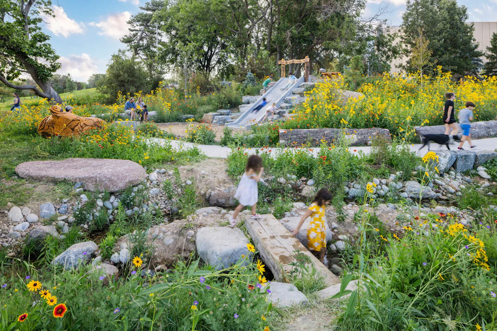 Nature-based play unfolds through native landscapes and a restored waterway